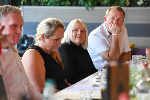 Guests at the table listening intently.