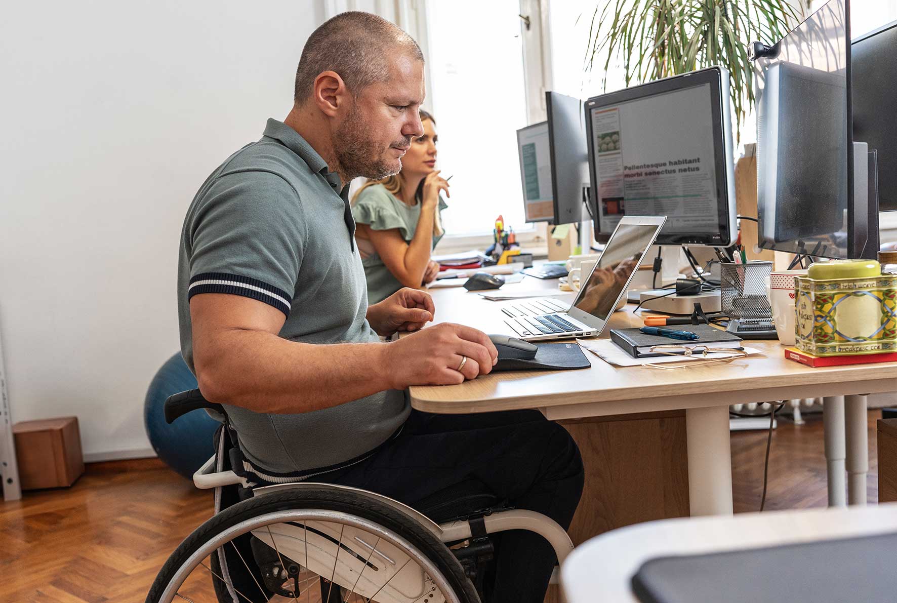 Man in wheelchair at a desk