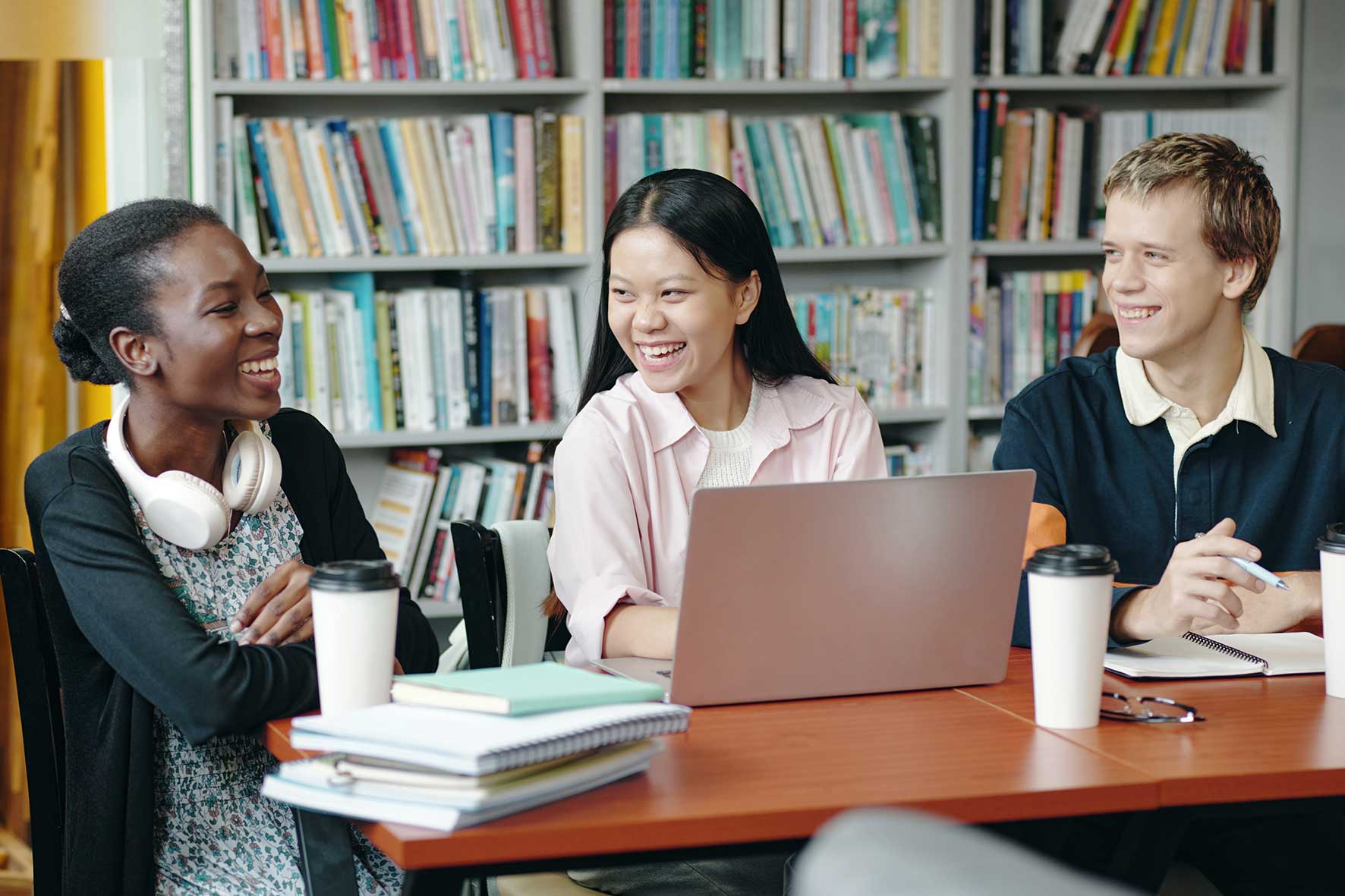 Students studying together in a library during a financial literacy lesson supported by The Open University.