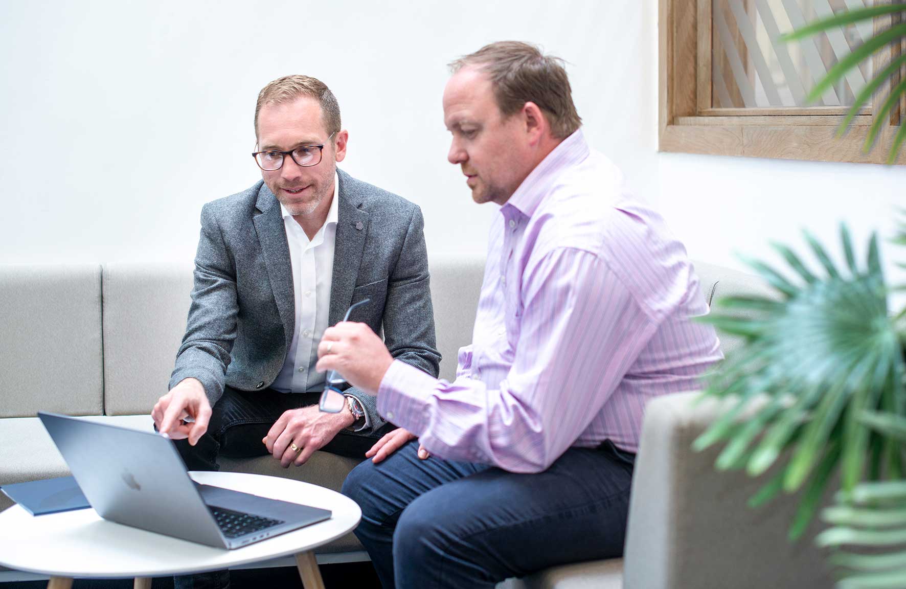 Bob Banks speaking with a client on a laptop at Tenacore’s Milton Keynes office.
