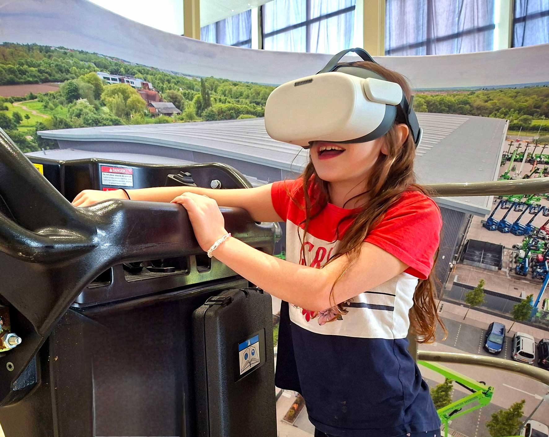 Child wearing a white VR headset, gripping a ride vehicle bar during a theme park attraction.