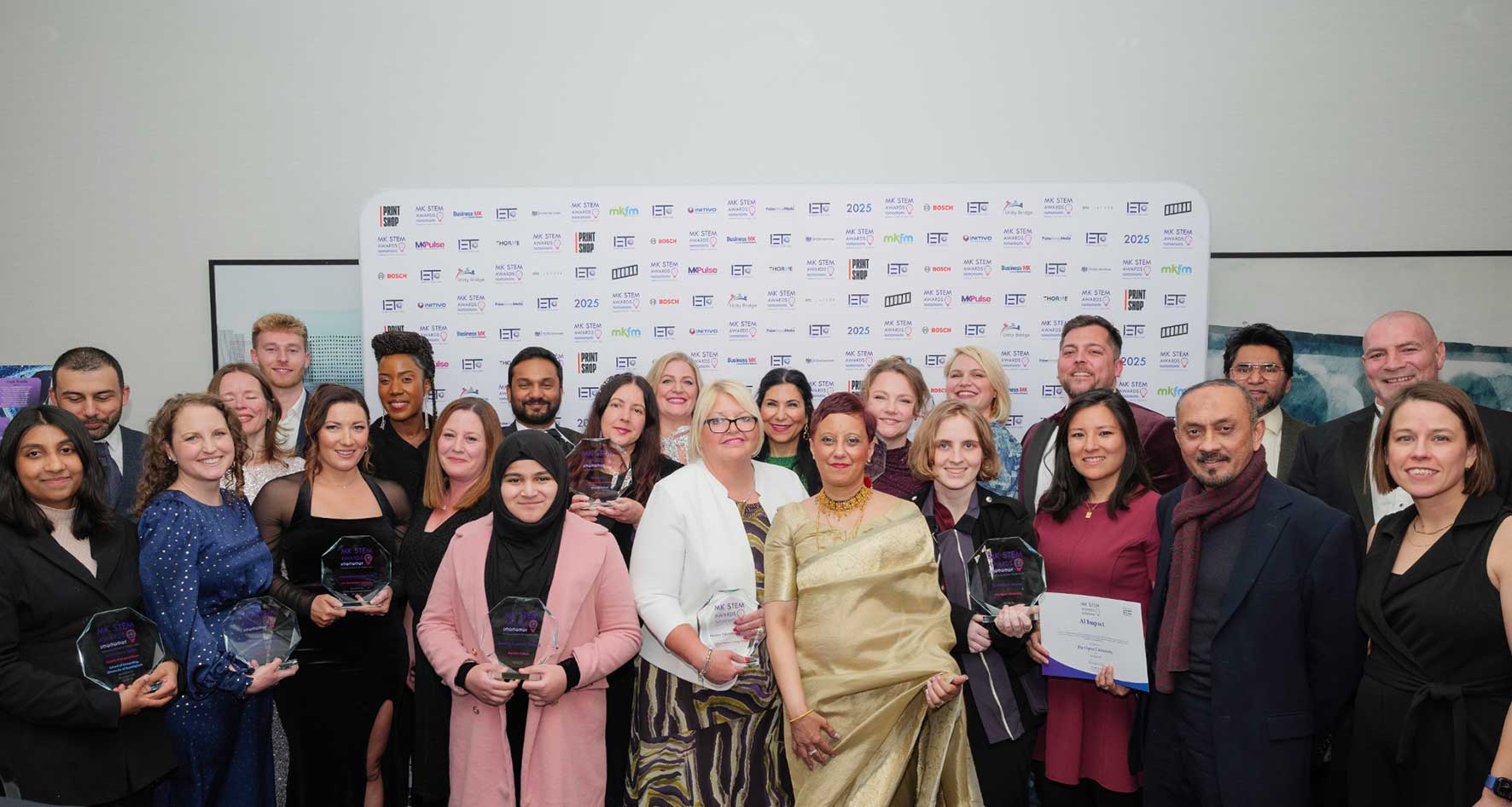 Group of award recipients holding trophies at a previous STEM awards ceremony in Milton Keynes.