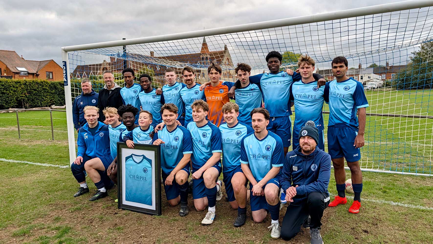 Stony Stratford FC first-team players and club representatives wearing blue football shirts featuring new sponsor Chapel Chophouse & Bar.